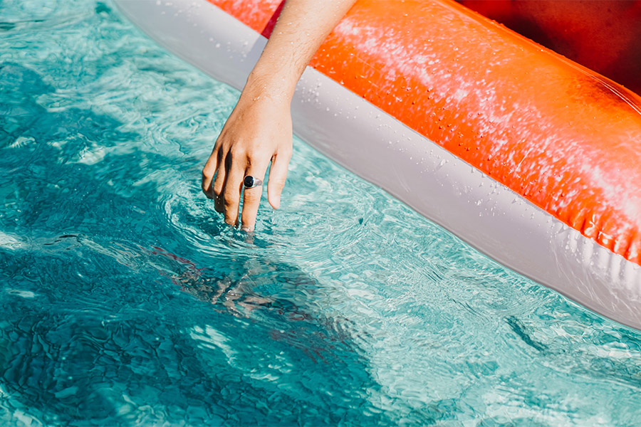 Person sitting on floatation toy in pool.